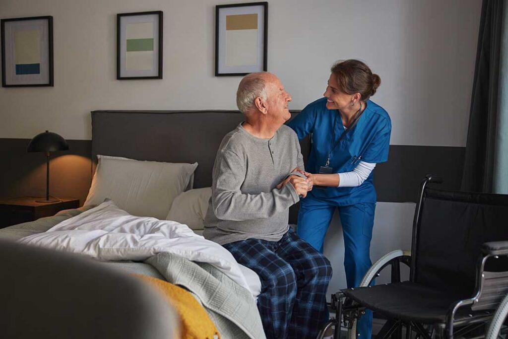 An older adult reviews paperwork with a caregiver in a warm, home-like living space.